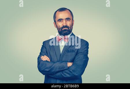 Relaxed dark brown haired bearded man, businessman with blue tie and white buttoned shirt. Happy boss with folded arms looking to you camera isolated Stock Photo