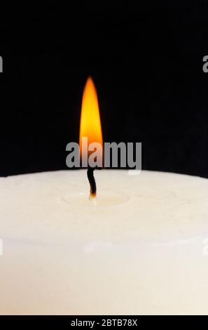 Burning paraffin candle close-up isolated on black Stock Photo
