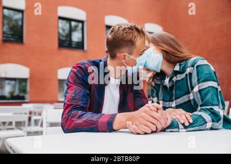 Couple in love, man and woman kissing each other in protective medical mask on face Stock Photo