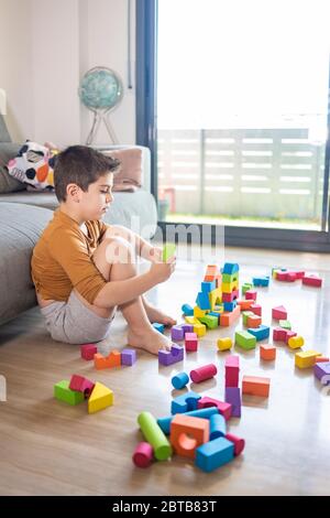 Bored child playing with blocks at home