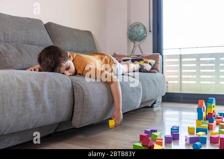 Bored child playing with blocks at home