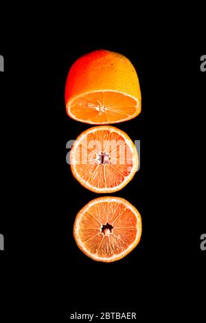 Sliced orange isolated on black background. Fruit chips. Stock Photo