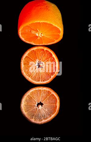 Sliced orange isolated on black background. Fruit chips. Stock Photo