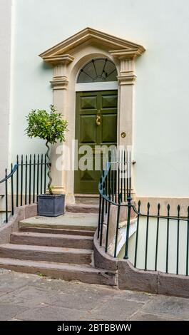 Elegant Georgian door with steps leading up to stone pediment and flanking columns on a street in Clifton village in Bristol UK Stock Photo