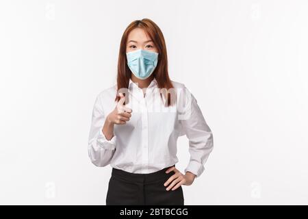 Nice work, keep up. Pleased and satisfied young asian female coworker praise nice job, delighted see person made good choice, show thumb-up and nod Stock Photo