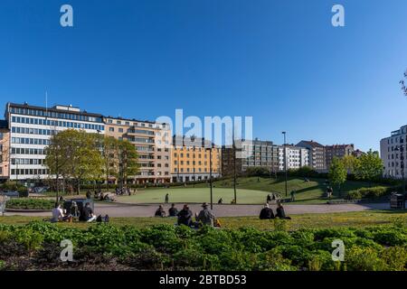 First warm spring days make people get outside and gather in public parks downtown Helsinki. Social distancing is being applied though. Stock Photo