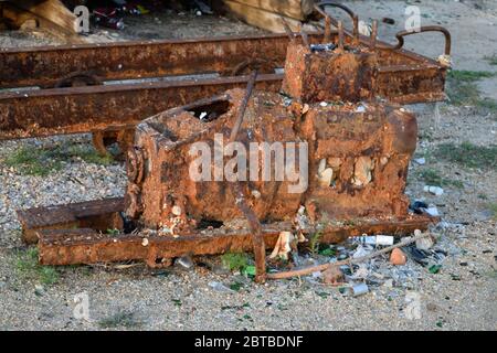 Rusty Piece of Old Machinery Lies Among Rubbish Outside the Abandoned Fish Factory on Olkhon Island, Lake Baikal, Russia Stock Photo