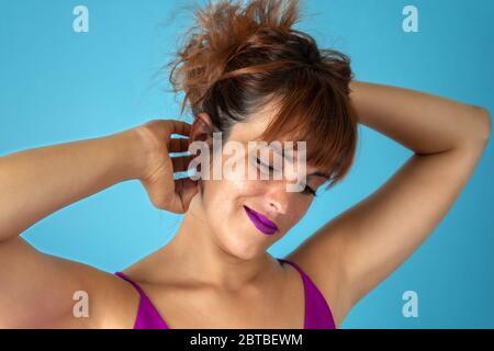 Young woman with red hair scratching vigorously her scalp and showing relief face Stock Photo
