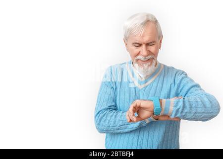 Planning Day. Senior bearded man in sweater standing isolated on white checking time on watch joyful Stock Photo