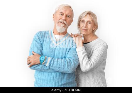 Freestyle. Senior couple standing isolated on white hugging smiling confident Stock Photo