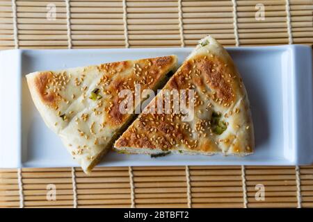 Top down view of Chinese halal food known as sesame scallion bread, a popular staple in Northern China. The bread is stuffed with spring onions and to Stock Photo