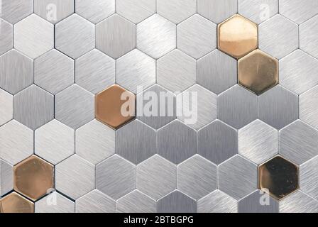 Silver? metal mosaic tile with golden elements. Metal mosaic in the form of honeycombs. Stock Photo