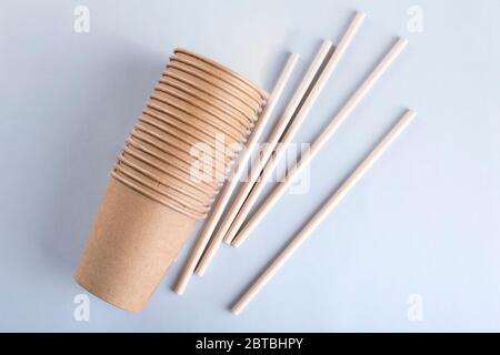 Disposable cups and drinking straws on light grey background. Stock Photo
