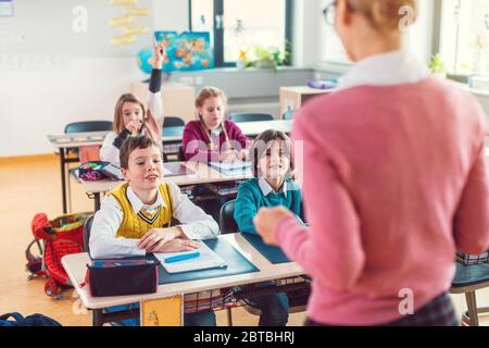 Teacher with her students in class at elementary school Stock Photo