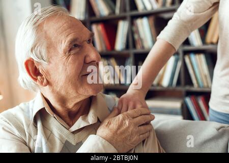 Father and daughter at home library man holding woman's hand looking at her happy Stock Photo