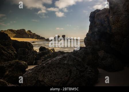 Long exposure photograph of the tide hitting the rocks of Guincho beach, Santa Cruz Stock Photo