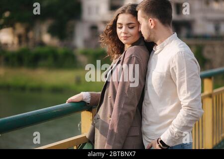 Hamdsome man kissing his girlfriend on the bride. Happy woman close her eyes. Space for text