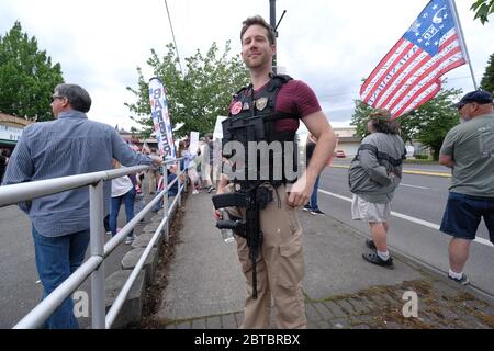 Vancouver, USA. 23rd May, 2020. A protester carries an AR-15 assault rifle during a rally in support of the Hugga Mug Diner which re-opened today in Vancouver, Wash., on May 23, 2020. The opening is a direct violation of Governor Jay Inslee's orders for non-essential business to remain closed at this time. (Photo by Alex Milan Tracy/Sipa USA) Credit: Sipa USA/Alamy Live News Stock Photo