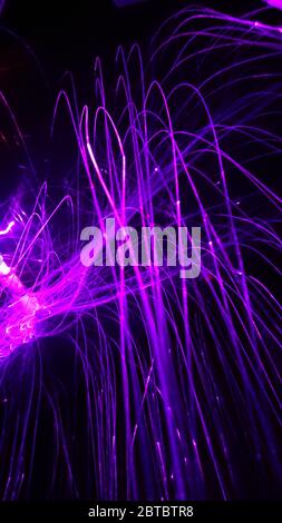 Overlaying wavy lines forming an abstract pattern on a dark background Stock Photo
