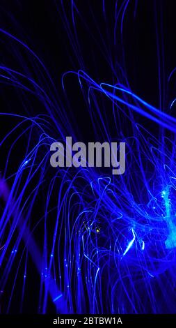 Overlaying wavy lines forming an abstract pattern on a dark background Stock Photo