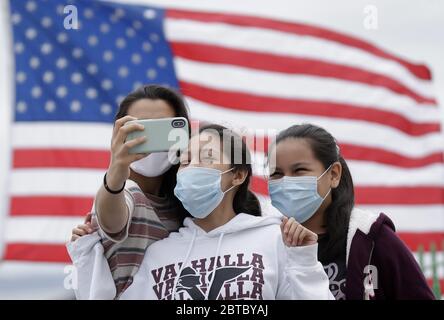 Rye, United States. 24th May, 2020. Kids take a selfie near an America Flag for Memorial Day Weekend at Rye Playland Beach during the Coronavirus Pandemic in New York City on Sunday, May 24, 2020. More than 5.3 million cases of COVID-19 have been reported worldwide resulting in over 343,000 deaths. Photo by John Angelillo/UPI Credit: UPI/Alamy Live News Stock Photo