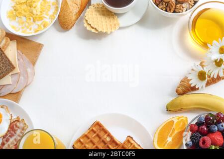 Healthy breakfast with muesli, fruits, berries, nuts, coffee, eggs, honey, oat grains and other on white background. Flat lay, top view, copy space fo