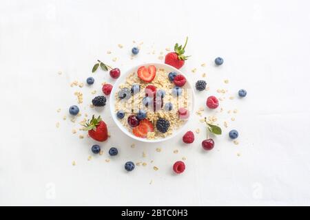 Oatmeal porridge in bowl topped with fresh berries, and homemade crunchy granola Stock Photo