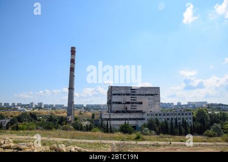 An old Soviet factory with a pipe. Abandoned Soviet industry. Stock Photo