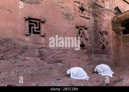 Piligrims at lalibela church stone wall Stock Photo