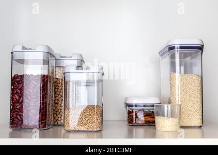 Clear Pantry Containers Filled with Non-Perishable Foods-- Dried Beans, Grains, Dried Peppers, Rice-- and Measuring Cup Stock Photo