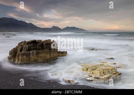 Rocks in breaking waves on Kaikoura coastline Stock Photo