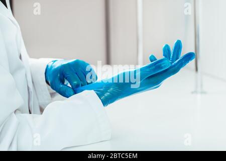 close up. doctor putting on protective gloves. Stock Photo