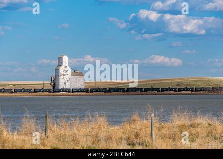 Sanctuary, SK/Canada- May 20, 2020: The historic grain elevator with railroad cars and water in Sanctuary, Saskatchewan Stock Photo