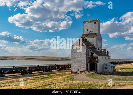 Sanctuary, SK/Canada- May 20, 2020: The historic grain elevator with railroad cars and water in Sanctuary, Saskatchewan Stock Photo