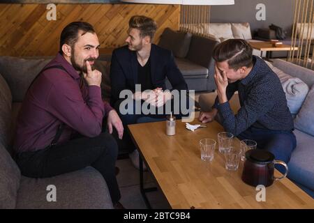 Men are distracted from playing chess because of mobile phones Stock Photo