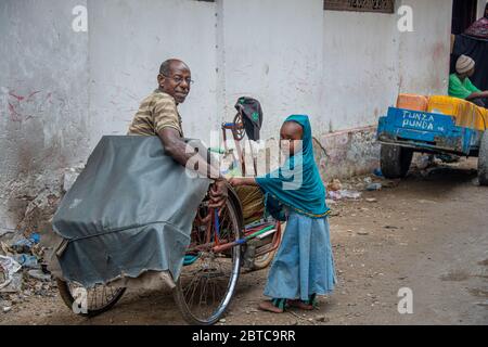 Muslim little girl with a man in a hand pedal bike Stock Photo