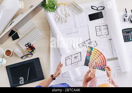 Color palette and apartment plans in hands of architect and engineer Stock Photo