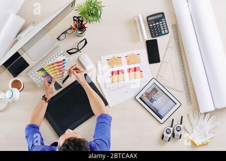 Interior designer choosing color scheme for the project of building he is working on, view from above Stock Photo