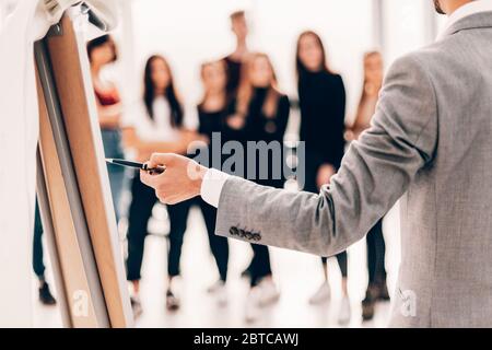 rear view . business man pointing with pen on a flipchart. Stock Photo