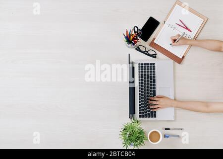 Businesswoman working from home during lockdown, checking e-mails and writing in planner Stock Photo