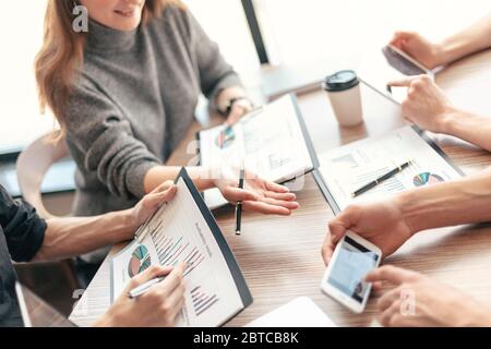 employee is using his smartphone to check the financial data. Stock Photo