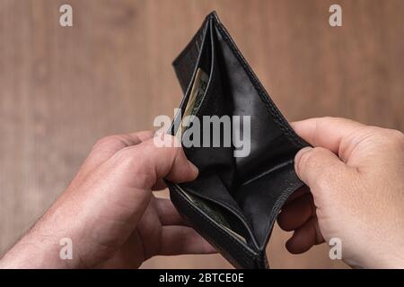 Empty leather wallet in the hands of a man, close-up. Poverty concept Stock Photo