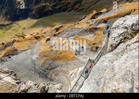 Tourists walking on the Thrill Walk, the cliff pathway located under Birg cableway station at Schilthorn mountain in the Alps, Switzerland Stock Photo