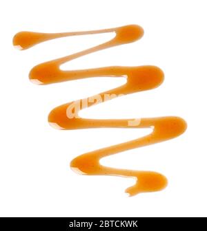 Caramel syrup drizzle isolated on white background. Splashes of sweet caramel sauce. Top view. Stock Photo
