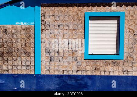 Faded ornate tiles cover a home with turquoise trim in Aveiro, Portugal Stock Photo
