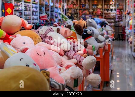 Gigantic soft stuffed plush toys in bins and on shelves on display for sale at a toy store in Chinatown Singapore Stock Photo