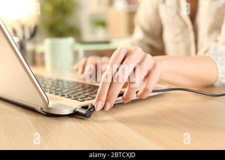 Close up of woman hands plugging battery charger on laptop at home Stock Photo