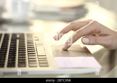 Side view close up of girl hand using touchpad on a laptop on a desk at home Stock Photo