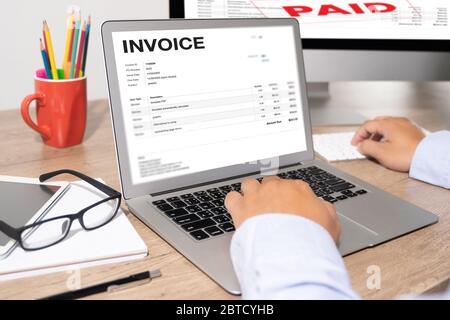 Businessman work Using The Computer Calculating  Invoice In Office Invoice Form and Accountant Checking Invoice Stock Photo