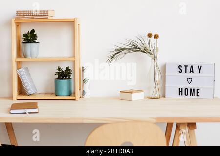 Image of modern table with notepad and flowers on it at home Stock Photo